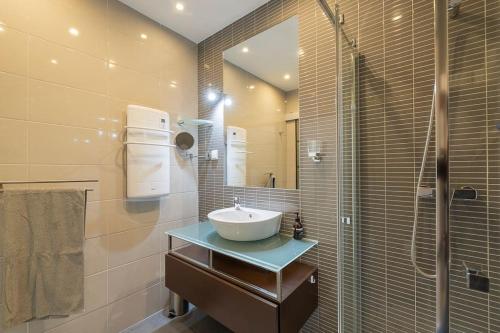 a bathroom with a sink and a shower with a mirror at Albufeira Old Town Center - VERASOL 1 in Albufeira