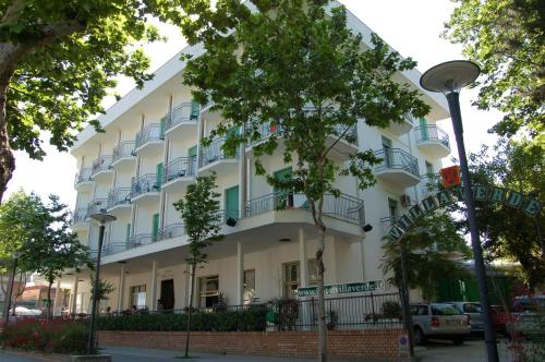 een groot wit gebouw met balkons in een straat bij Hotel Villa Verde in San Mauro a Mare