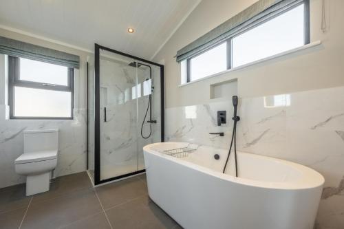 uma casa de banho branca com uma banheira e um WC em 14 Westgate em Burnham Market