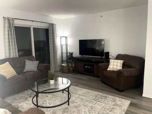 a living room with two couches and a flat screen tv at Luxury Modern Condo by the Lake - Breezy Escape in Branson