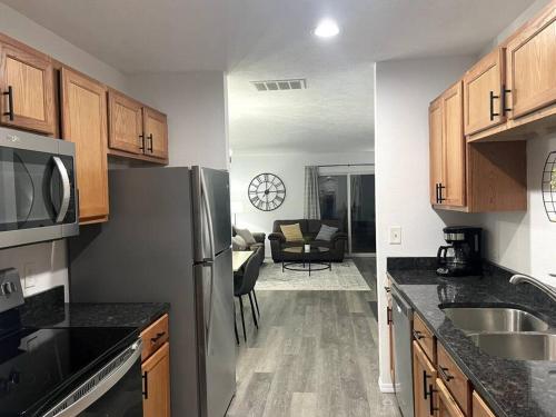 a kitchen with stainless steel appliances and a living room at Luxury Modern Condo by the Lake - Breezy Escape in Branson