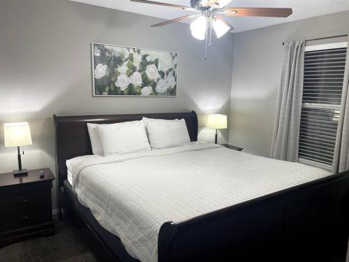 Schlafzimmer mit einem Bett und einem Deckenventilator in der Unterkunft Luxury Modern Condo by the Lake - Breezy Escape in Branson