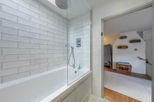 a bathroom with a tub and a glass shower stall at Fox Cottage in South Creake