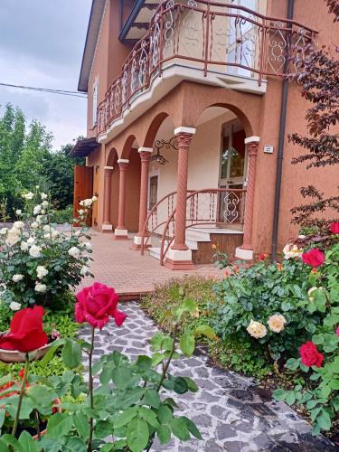 un edificio con balcón y flores delante de él en LILY - STORIE DEL BOSCO -, en San Felice sul Panaro