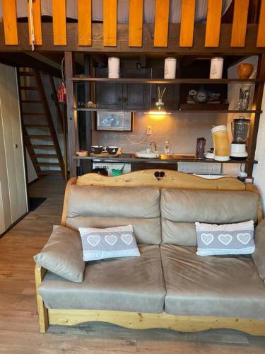 - un canapé brun dans une chambre avec cuisine dans l'établissement Duplex sur Morzine avec vue imprenable, à Morzine