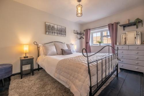 a bedroom with a bed and a dresser and a window at Homestead in Northrepps