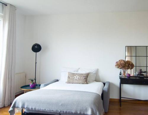 une chambre blanche avec un lit et une table dans l'établissement Cozy 1 bedroom flat,free parking, close to center, à Cannes