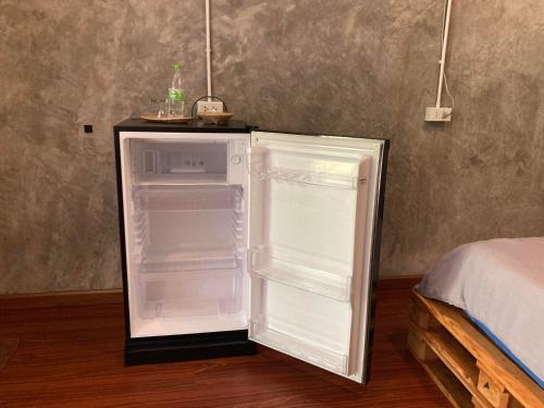 an empty refrigerator with its door open in a room at Koh Mak Homestay in Ko Mak