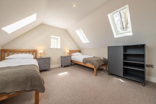 a attic bedroom with two beds and a tv at The Goosebec in Burnham Market