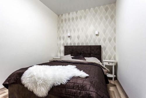 リヴィウにあるComfortable Apartmentsのベッドルーム1室(白い毛布付きのベッド1台付)
