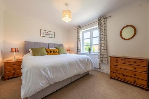 a bedroom with a large white bed and a window at Birch Cottage in Northrepps