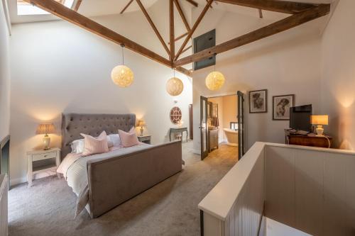 1 dormitorio con 1 cama con almohadas rosas en Scouts Cottage en Snettisham