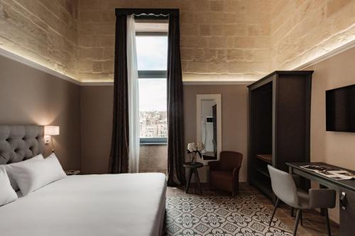 a hotel room with a bed and a window at IBB Hotel Palazzo Bettina Malta in Birgu