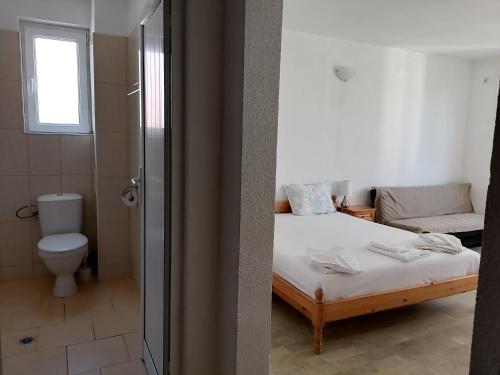 uma casa de banho com uma cama, um WC e um chuveiro em Mechta Family Hotel em Obzor