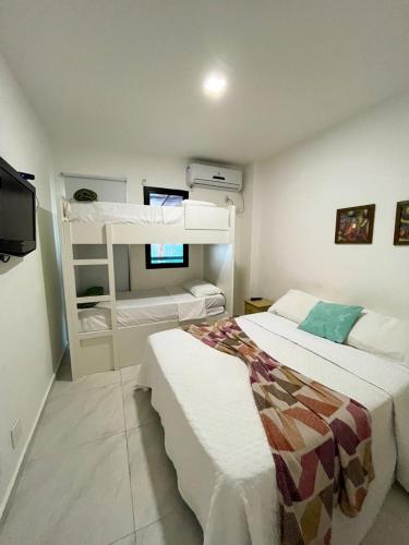 1 Schlafzimmer mit 2 Etagenbetten und einem TV in der Unterkunft Apartamento no Porto Real Resort com vista para praia para 6 adultos e 4 adolescentes in Mangaratiba