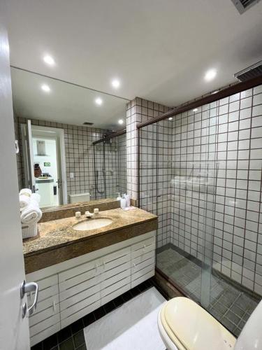 ein Badezimmer mit einem WC, einem Waschbecken und einem Spiegel in der Unterkunft Apartamento no Porto Real Resort com vista para praia para 6 adultos e 4 adolescentes in Mangaratiba