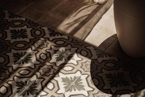 a bathroom with a tile floor with a patterned floor at IBB Hotel Palazzo Bettina Malta in Birgu
