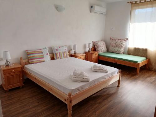 a bedroom with a bed and two chairs and a window at Mechta Family Hotel in Obzor