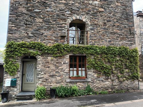 a stone building with a window and ivy at Appartneuville in Vielsalm