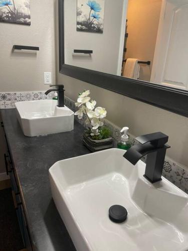 a bathroom with a white sink and a mirror at Newly Remodeled Lover’s Luxury Condo with Upgrades in Branson