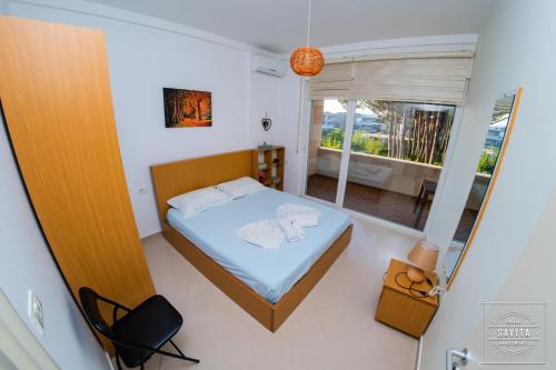 a small bedroom with a bed and a balcony at Gjiri i Lalzit - Savita Apartments - Kompleksi Turistik Lura 2 in Mullini i Danit