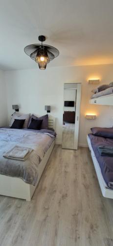 een slaapkamer met 2 bedden en een spiegel bij Apartament Orania 60m2 z ogrodem, tarasem, grillem in Gdańsk