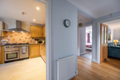 a kitchen and living room with a clock on the wall at South View in West Runton