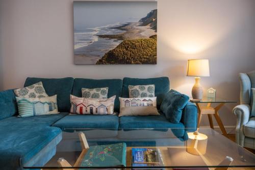 a living room with a blue couch and a table at South View in West Runton