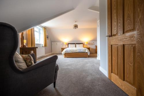 a bedroom with a bed and a couch and a chair at South View in West Runton