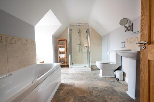 a bathroom with a tub and a toilet and a shower at South View in West Runton