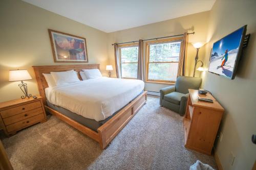 ein Schlafzimmer mit einem Bett und einem Stuhl in der Unterkunft Snake River 26 in Keystone