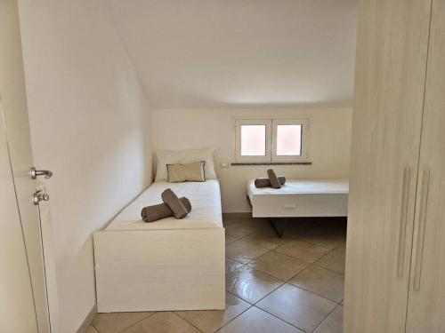 a bedroom with two beds and a window at Borgio Verezzi appartamento con parcheggio in Borgio Verezzi