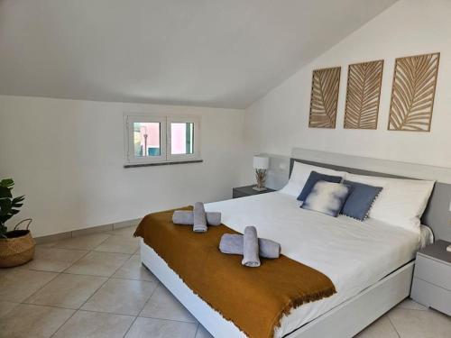 a bedroom with a large bed with two towels on it at Borgio Verezzi appartamento con parcheggio in Borgio Verezzi