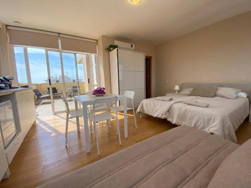 een slaapkamer met een bed en een tafel met stoelen bij Attic with great terrace close to the sea in El Campello