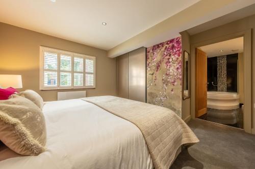 a bedroom with a large bed and a bathroom at Pinchen House in South Creake