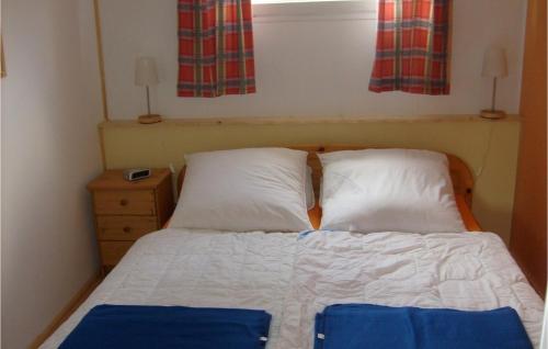 ein Schlafzimmer mit einem Bett mit zwei Kissen und einem Fenster in der Unterkunft Ferienhaus Seeigel L in Süssau