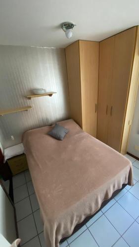 una piccola camera da letto con un letto con un cuscino blu di Kit sudoeste a Brasilia