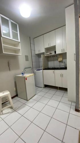una cucina con armadi bianchi e pavimenti piastrellati bianchi di Kit sudoeste a Brasilia