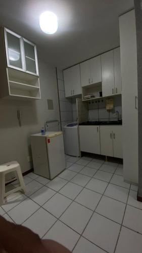 una cucina con armadi bianchi e pavimenti piastrellati bianchi di Kit sudoeste a Brasilia