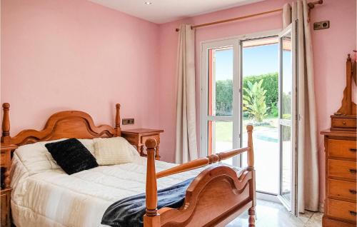 カンダスにあるNice Home In Antromero With Kitchenのピンクの壁のベッドルーム(ベッド1台、窓付)