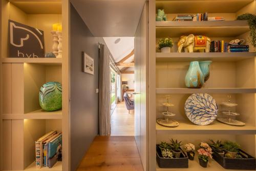 a hallway with shelves with vases and plants at Horse Yard Barn in Warham
