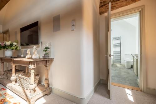 a hallway with a console table and a sliding glass door at Horse Yard Barn in Warham