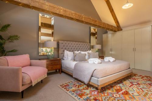 a bedroom with a bed and a chair at Horse Yard Barn in Warham