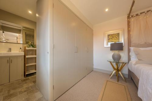 a bedroom with a white closet and a bed and a sink at Horse Yard Barn in Warham