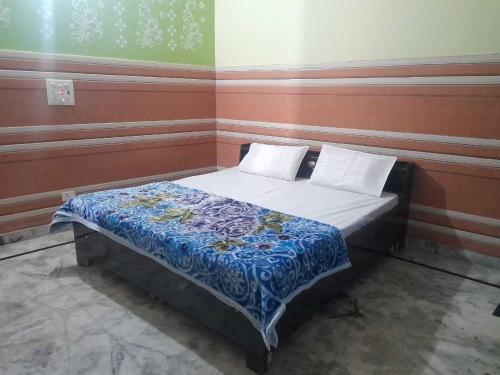 a bedroom with a bed with a blue comforter at OYO Kk Hotel in Meerut