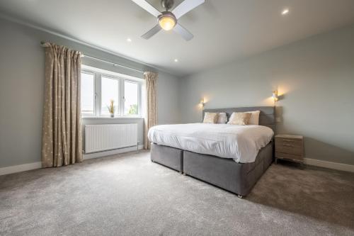 a bedroom with a bed and a ceiling fan at Appletrees in Burnham Market