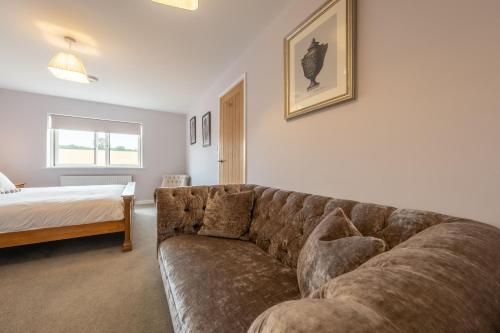 a living room with a couch and a bed at Field View in Sedgeford
