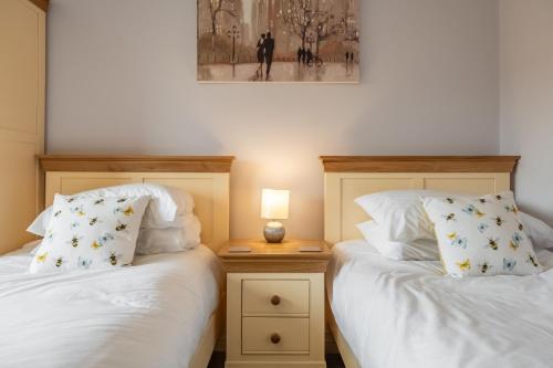 two beds sitting next to each other in a bedroom at Field View in Sedgeford