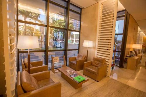 Elle comprend un salon meublé et une grande fenêtre. dans l'établissement CULLINAN HOTEL flat de luxo apartamento 302, à Brasilia