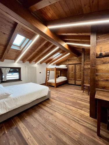 a bedroom with a bed and a wooden floor at La Louye su La Goumba in Pontboset